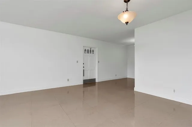 an empty room with chandelier fan