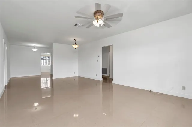 an empty room with fan and entrance