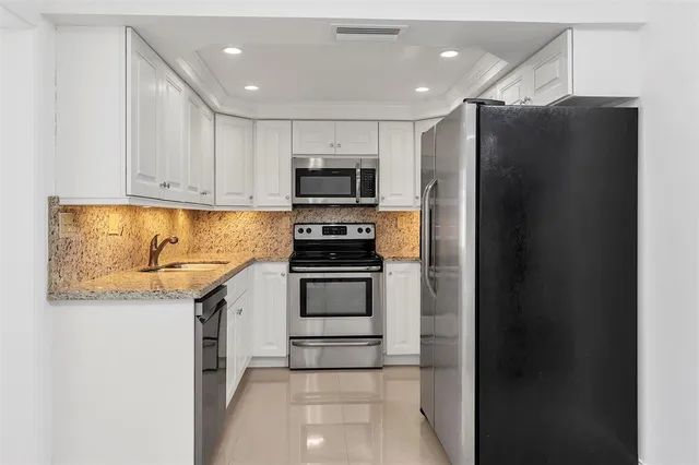 a kitchen with stainless steel appliances a refrigerator and a stove top oven