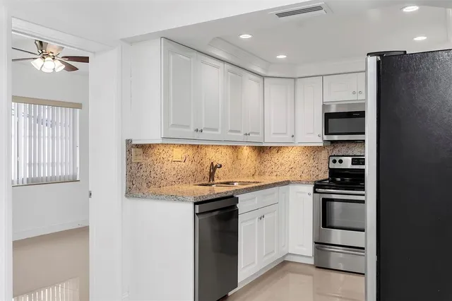 a kitchen with stainless steel appliances granite countertop a stove and a refrigerator