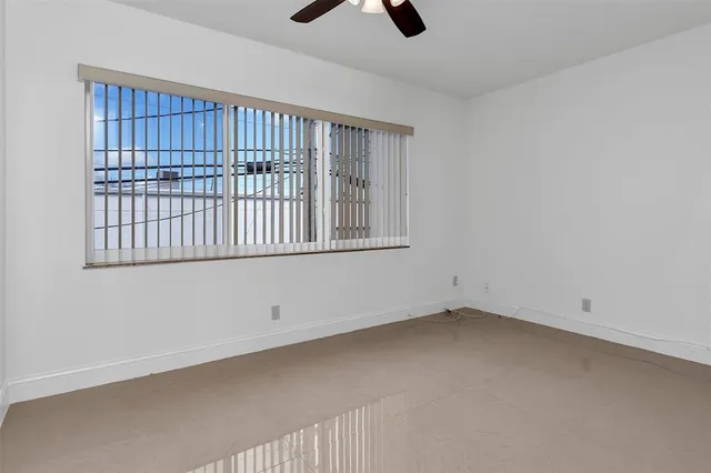 an empty room with chandelier fan
