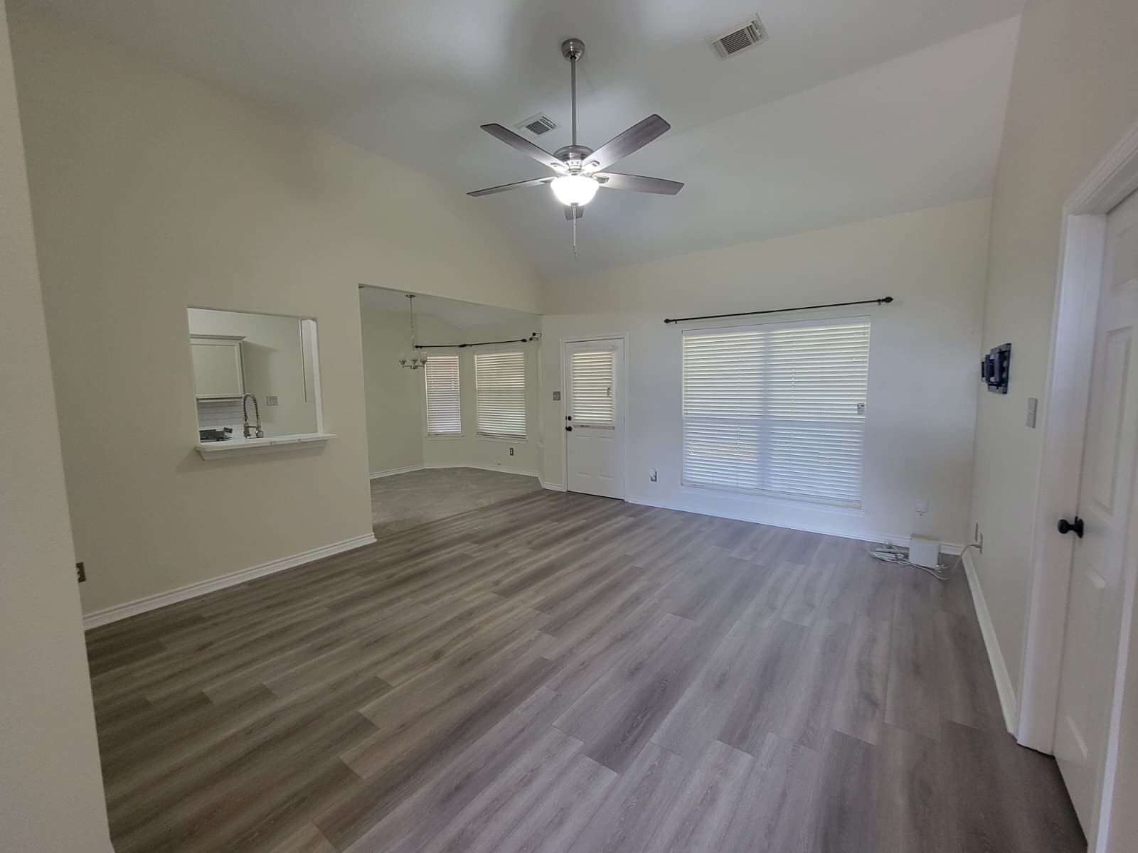 320 Old San Felipe Road Sealy, TX 77474 - Photo 9 of 12 Spacious living area with elegant wood flooring, high ceilings, and abundant natural light from large windows.