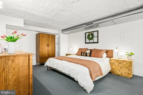 a spacious bedroom with a bed and a window