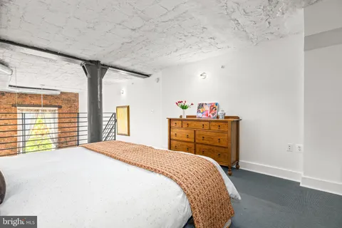 a bed sitting in a bedroom next to a window