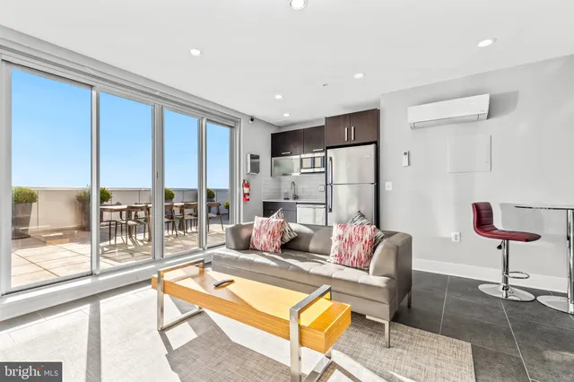 a living room with furniture and a floor to ceiling window