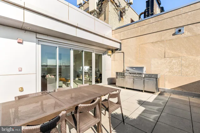 a view of a patio with table and chairs and wooden fence
