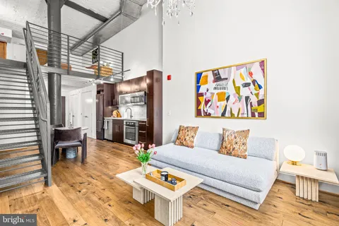 a living room with furniture a dining table and chairs with wooden floor