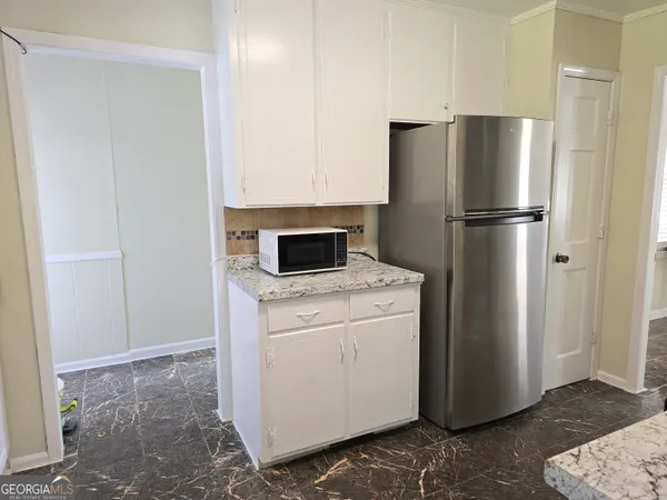a kitchen with granite countertop white cabinets and white appliances