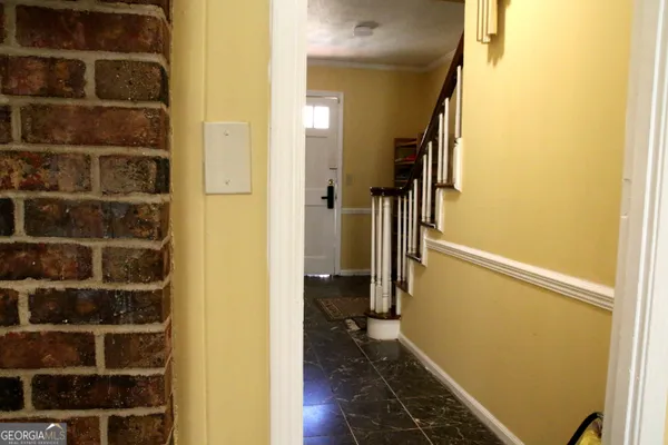 a view of a hallway with wooden floor and a window