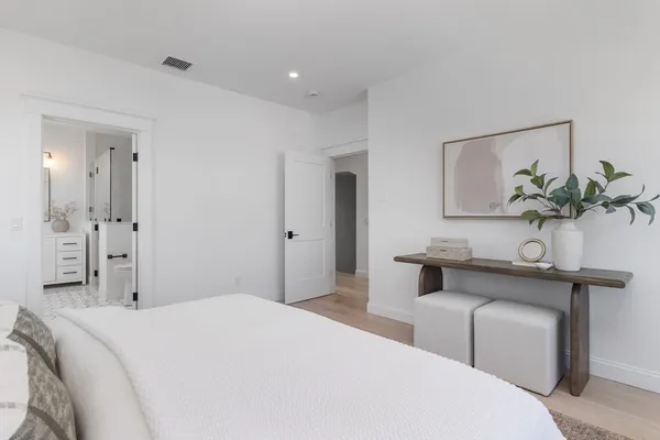 a bedroom with a bed and a potted plant