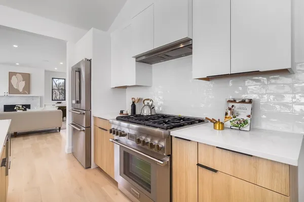 a kitchen with stainless steel appliances granite countertop a stove a refrigerator and a white cabinets