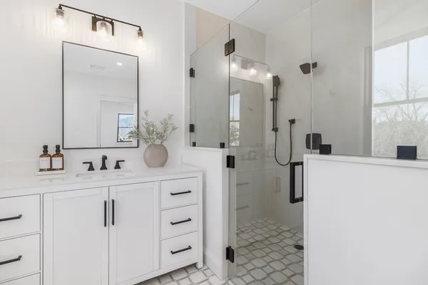 a bathroom with a double vanity sink mirror and shower