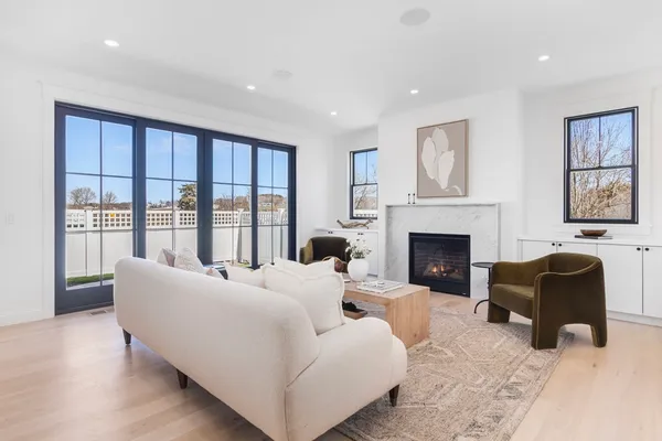 a living room with furniture large window and a fireplace