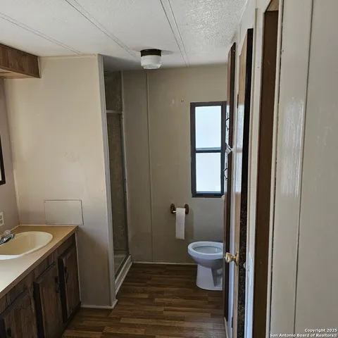 a bathroom with a sink a toilet and shower