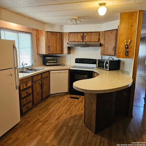 a kitchen with a sink a stove a refrigerator and a stove