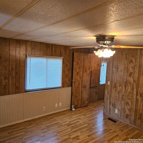 a view of a hallway with wooden floor and a chandelier
