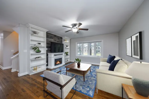 a living room with furniture a flat screen tv and a fireplace