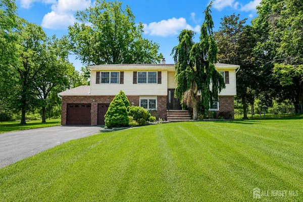 a front view of a house with a yard and trees