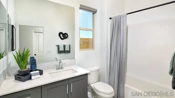 a bathroom with a granite countertop sink a toilet and a mirror