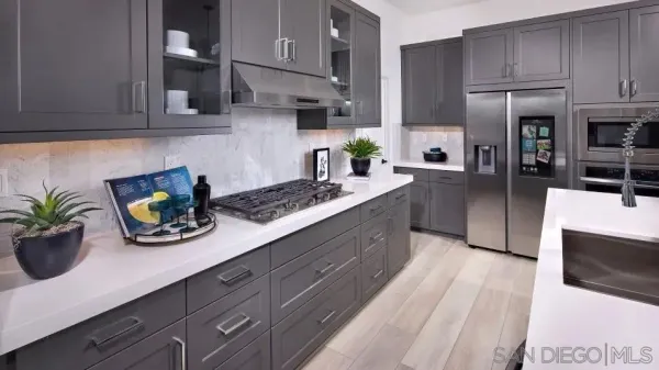 a kitchen with stainless steel appliances kitchen island granite countertop a sink a stove and a wooden floors