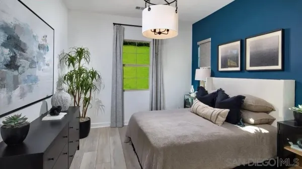 a bedroom with bed and a potted plant