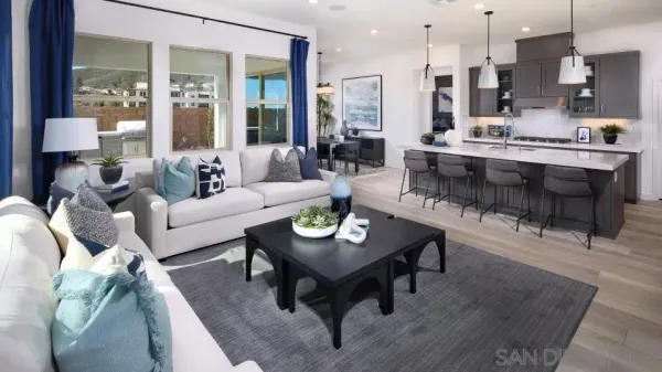 a living room with furniture kitchen view and a large window