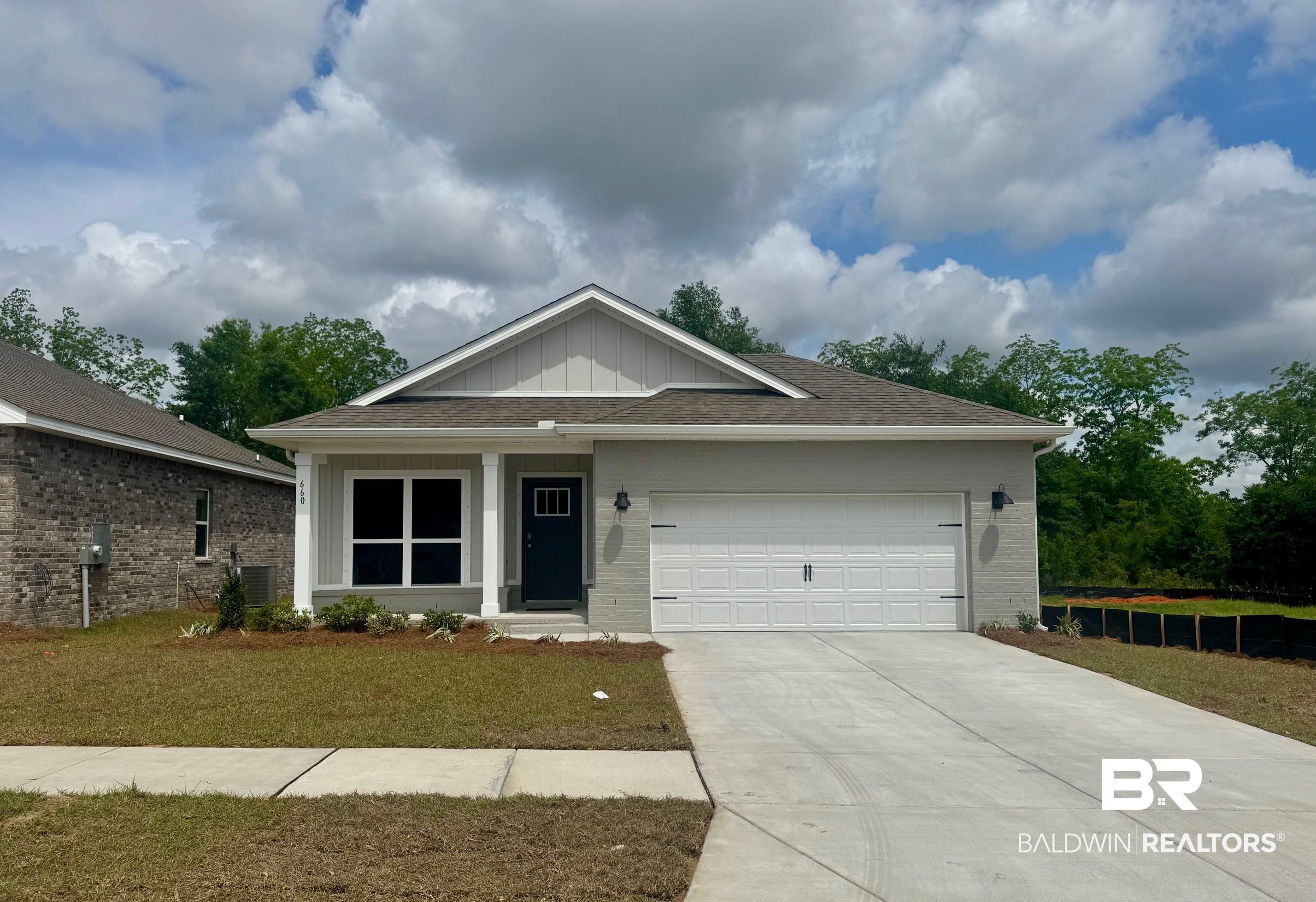 660 Overland Drive Fairhope, AL 36532 - Photo 1 of 40 Ranch-style home featuring board and batten siding, a garage, brick siding, a front lawn, and concrete driveway