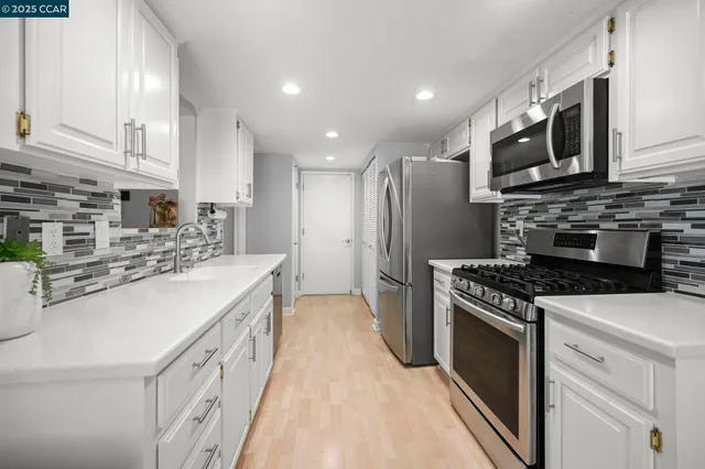 a kitchen with stainless steel appliances a stove microwave and sink