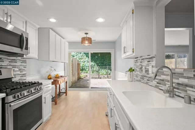 a kitchen with stainless steel appliances a sink a stove a microwave and cabinets