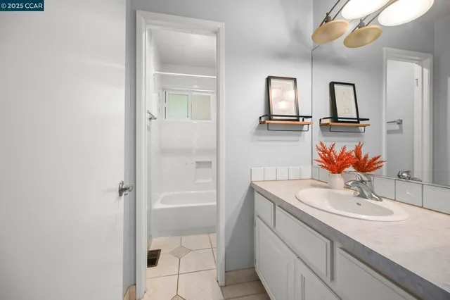 a white bath tub sitting next to a white sink and vanity