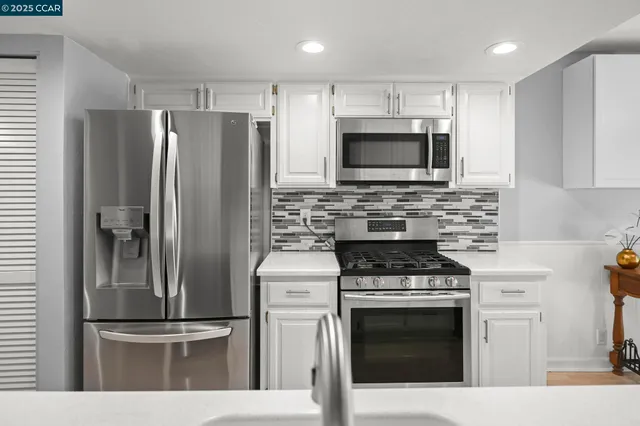 a kitchen with stainless steel appliances wooden cabinets a stove and a refrigerator