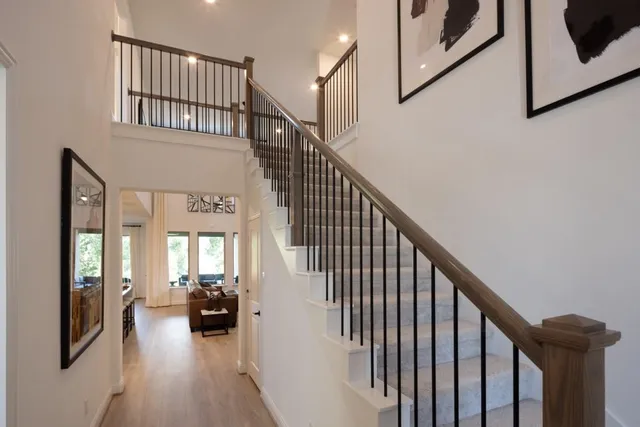 a view of staircase and living room with wooden floor