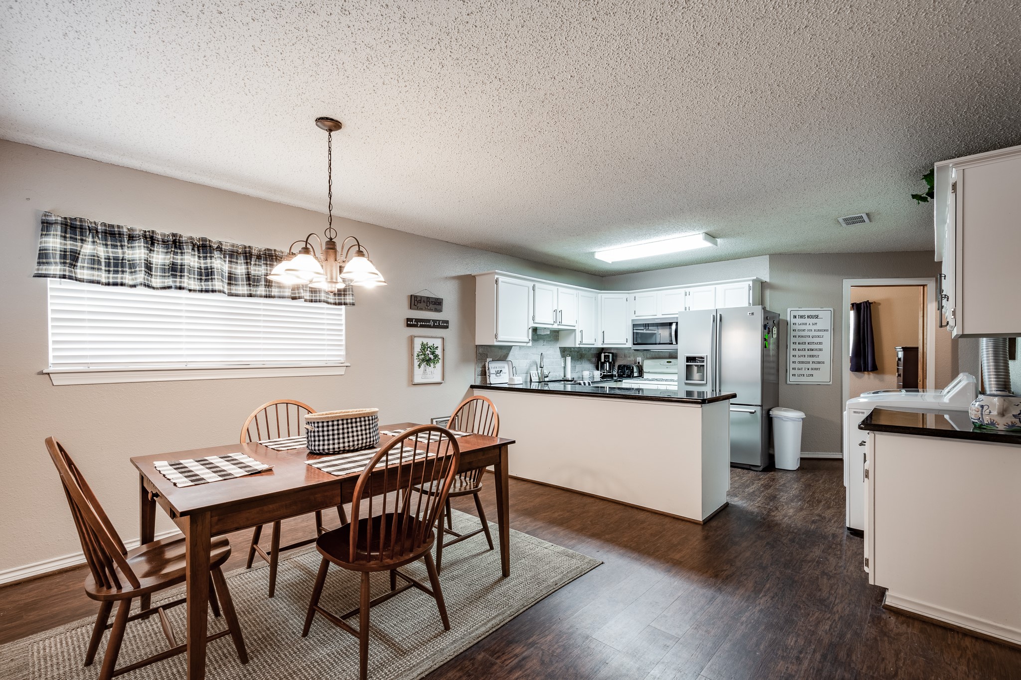 16410 Farm To Market 1485 Conroe, TX 77302 - Photo 25 of 47 a kitchen with stainless steel appliances kitchen island granite countertop a dining table chairs and white cabinets