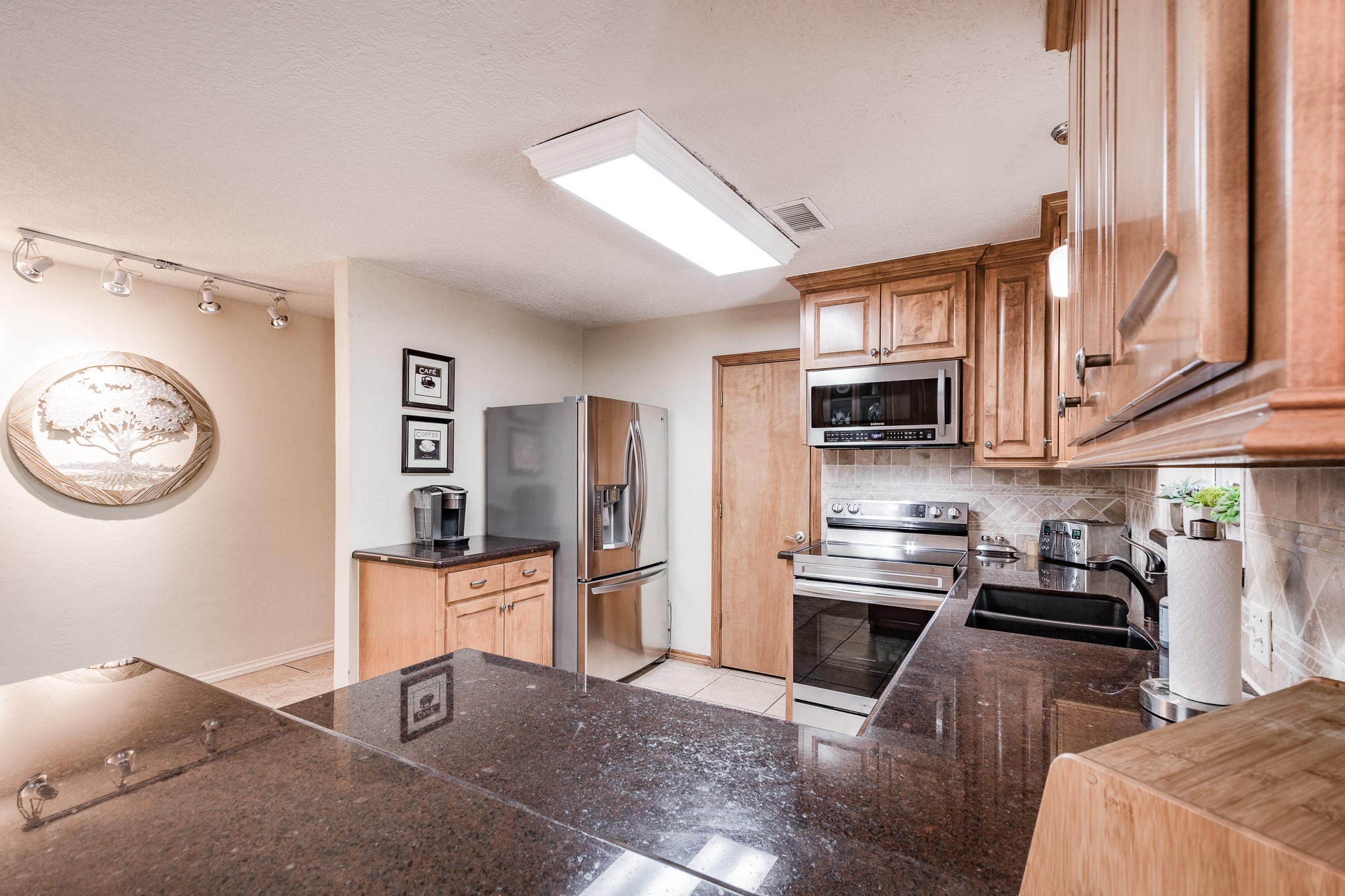 16410 Farm To Market 1485 Conroe, TX 77302 - Photo 33 of 47 a kitchen with stainless steel appliances granite countertop a stove top oven a sink a counter space and cabinets