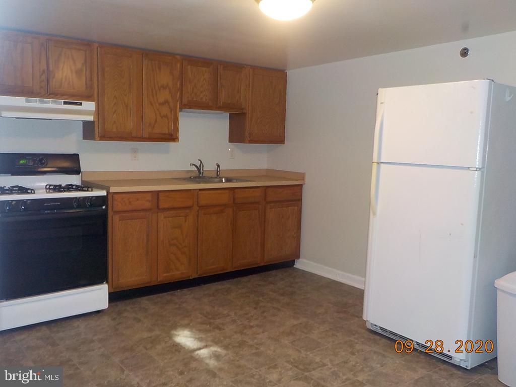 1807 Millers Road, Unit B Wilmington, DE 19810 - Photo 2 of 7 a kitchen with a sink a stove and refrigerator