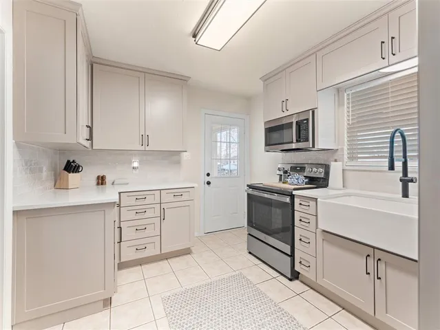 a kitchen with granite countertop white cabinets and stainless steel appliances
