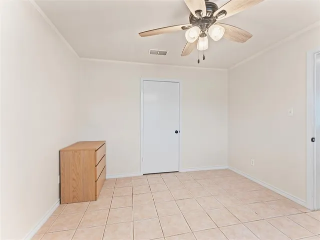 an empty room with a ceiling fan and carpet