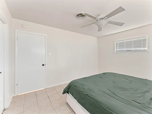 a bedroom with a bed and a ceiling fan