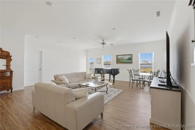 a living room with furniture wooden floor and a flat screen tv