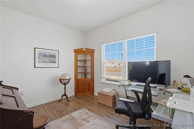 a view of a workspace with furniture and a window