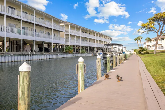 a front view of a building with glass windows and tree