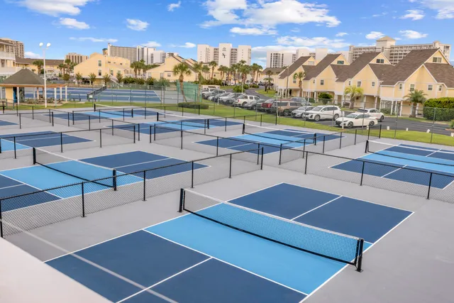 a view of a tennis court with large trees