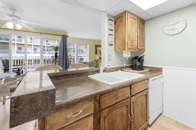 a view of a kitchen with granite countertop a sink and a stove