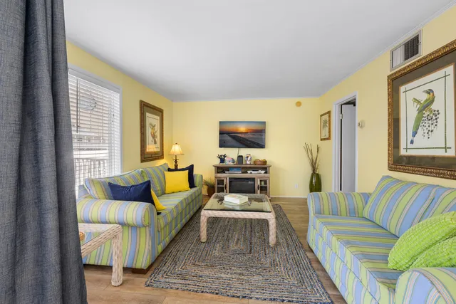 a living room with furniture wooden floor and a large window