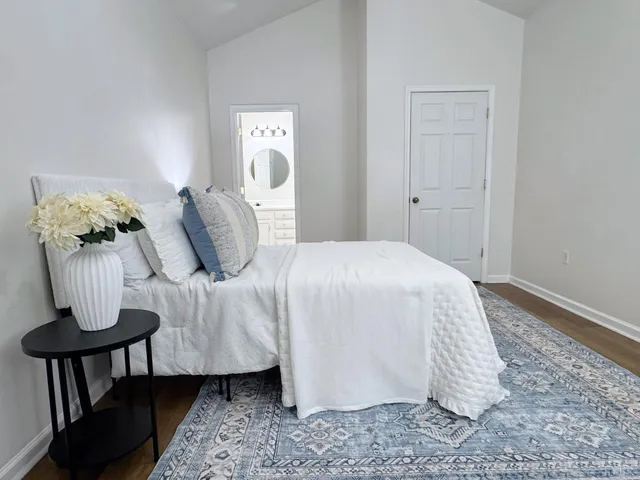 a bedroom with a bed and wooden floor