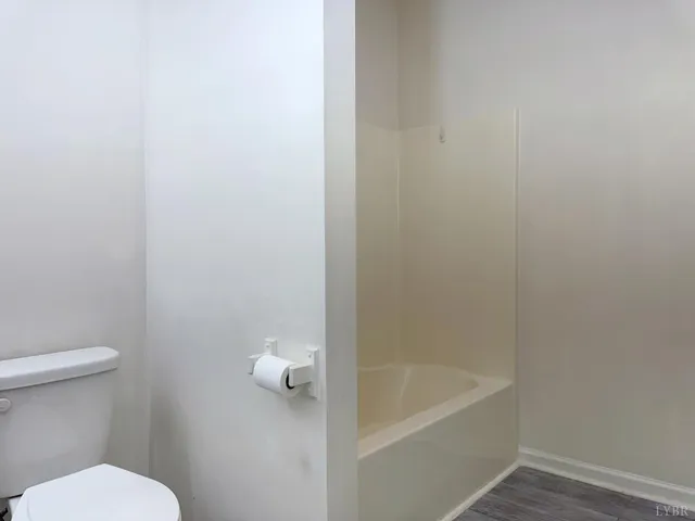 a white toilet sitting next to a bath tub