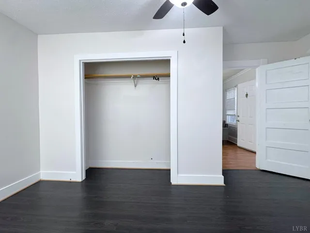 an empty room with wooden floor and closet