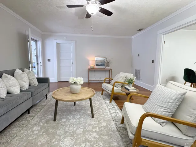 a living room with furniture and a wooden floor