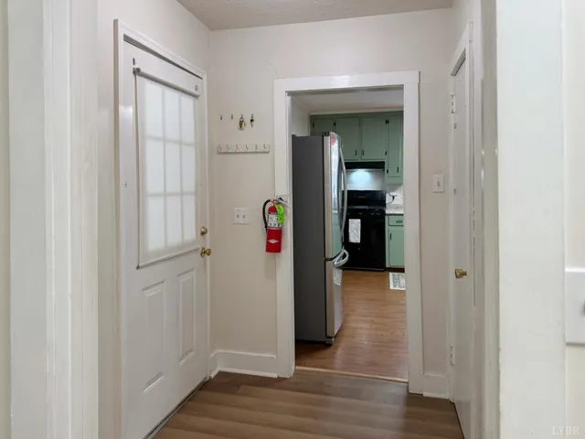 a view of a hallway with wooden floor and closet