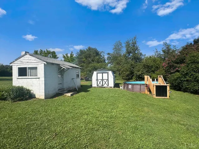 a view of a house with a backyard and swimming pool